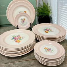 a stack of pink plates sitting on top of a wooden table