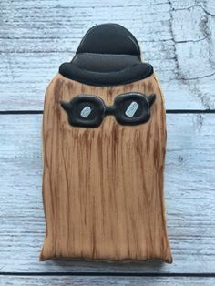 a wooden toy with glasses and a hat on it