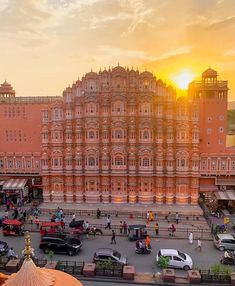 the sun is setting in front of an ornate building