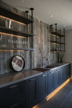 a modern kitchen with stainless steel appliances and dark wood cabinets, along with built - in shelving