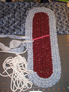 a crocheted red and white object laying on top of a table