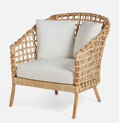 a wicker chair with white pillows on it's back and seat padding