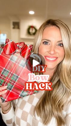 a woman holding up a red and green plaid wrapped present in front of her face with the words diy bow hack written on it