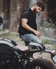 a man sitting on the back of a motorcycle