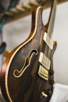 a close up of an electric guitar with wood grained body and fretwork