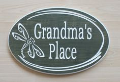 a wooden sign that says grandma's place on the side of a wall with a butterfly