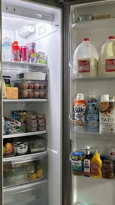 an open refrigerator with milk, yogurt, and other food items in it