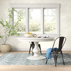 a white table with two black chairs in front of it