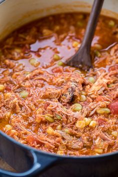 a large pot filled with chili and meat in a broth, garnished with beans