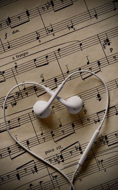 an earbud in the shape of a heart on sheet music