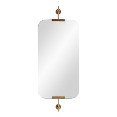 a mirror hanging on a wall with a gold frame and metal fittings around it