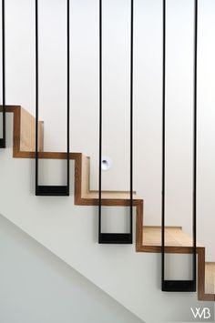 an image of a stair case going up the side of a staircase with wood and metal handrails