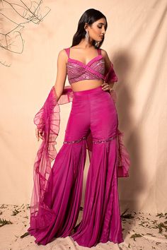 Mulberry pink bralette highlighted with embroidery, V-Neck, sleeveless and tie-up at the back. Comes with sharara and dupatta.
Component: 3
Embroidered
Neckline: V-Neck
Sleeve Length: Sleeveless
Fabric: Chanderi, Crepe, Net, Organza
Color: Purple
Bugle beads, sequins and embellishments
Ruffle pleats at the neckline
Ruffle dupatta - Aza Fashions Blouse And Sharara Set, Purple Jumpsuit Outfit, Indian Jumpsuit, Mehandi Outfit, Mehandi Outfits, Indian Outfits Modern, Kajol Saree, Embroidered Sharara, Sharara Designs