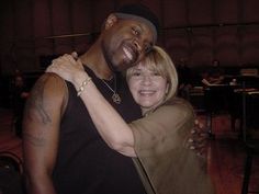 a man and woman hugging each other in an auditorium