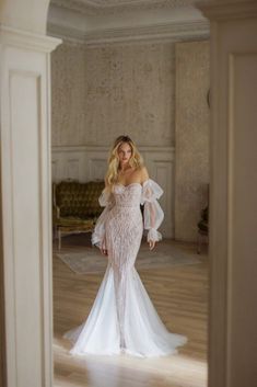 a woman in a white wedding dress is posing for the camera