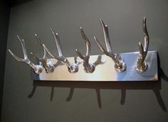 four metal deer heads mounted to a wall