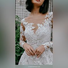 a woman in a wedding dress posing for the camera with her hands on her hips