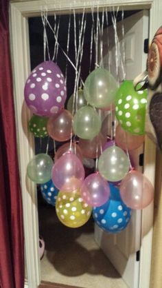 a bunch of balloons that are hanging from a door