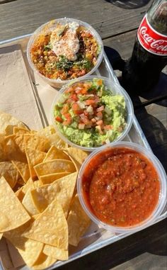 a tray filled with chips, salsa and guacamole