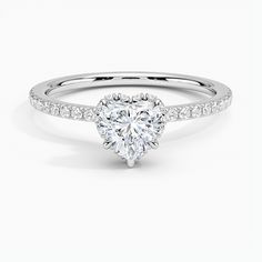 a heart shaped diamond engagement ring with diamonds on the band and side stones in white gold