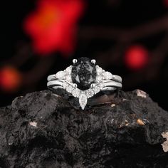 a black diamond ring sitting on top of a rock