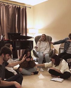 a group of people sitting on the floor in front of a piano