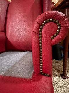 a red chair with beading on the arm rest