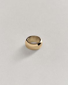 a gold ring sitting on top of a white surface