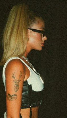 a woman with tattoos on her arm and chest