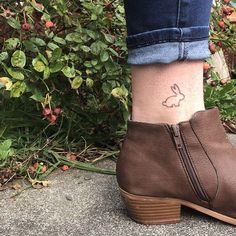 a woman's foot with a small tattoo on her ankle and a bunny head