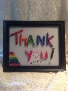 a framed thank you sign with crayons in it