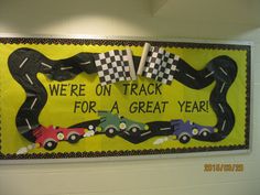 a sign that says we're on track for a great year with cars and checkered flags