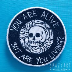 a patch with the words you're alive and a skull on it