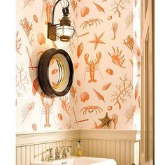 a bathroom with a sink, mirror and wallpaper