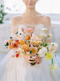 a woman sitting on a couch holding a bouquet of flowers