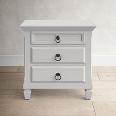 a white nightstand with two drawers on top of it and a wooden floor next to it