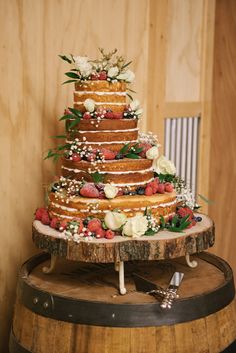 a three tiered cake sitting on top of a wooden barrel