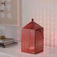 a red lantern sitting on top of a white table next to a stack of books