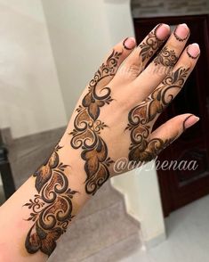 a woman's hand with henna tattoos on it