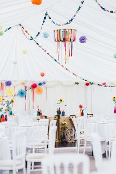 the inside of a white tent with tables and chairs