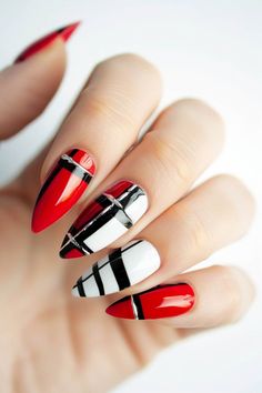 Close-up of hand showcasing stiletto nails painted with a glossy red, black, and white plaid design. Tropical Patterns