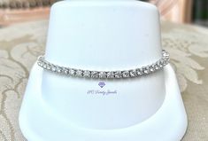 This Moissanite tennis bracelet is gorgeous and eye-catching. This glamorous bracelet embellishes the wrist with 53 (3mm) super sparkly D colorless Moissanites. I offer the bracelet in 6.2 inches long or 7 inches long, with a box clasp & safety. The bracelet is rhodium plated over 925 sterling silver. This bracelet would look amazing with my 3mm D colorless half eternity band. To view the half eternity band copy & paste this link:  https://www.etsy.com/listing/1063013651/3mm-d-colorless-moissanite-rhodium?click_key=1f493f1ce10b155dc792b8e2fb24b16dcbe48d99%3A1063013651&click_sum=fd251225&ref=shop_home_active_13&frs=1&crt=1&sts=1 This bracelet can also be made in 10k or 14k gold. Please message me for the price. *EACH MOISSANITE HAS BEEN TESTED FOR AUTHENTICITY The rhodium plating helps ster Fine Jewelry Diamond Bracelet With Vs Clarity As Gift, Fine Jewelry Diamond Bracelet Gift With Vs Clarity, Vvs Clarity Sterling Silver Diamond Bracelet For Anniversary, Vs Clarity Diamond Bracelet For Wedding, Half Eternity Band, Box Clasp, Silver Box, Copy Paste, Eternity Band