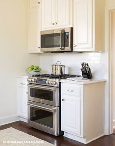 a stove top oven sitting inside of a kitchen next to a microwave above a counter