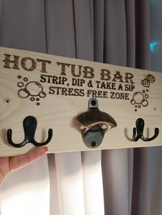 there is a sign that says hot tub bar and two hooks hanging from the wall