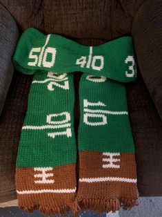 two green and brown scarfs sitting on top of a couch