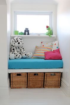 a dog sitting on top of a blue bench next to two baskets filled with stuffed animals