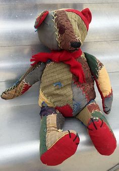 a teddy bear that is sitting on some metal steps with a red scarf around it's neck