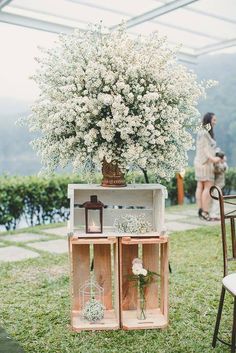 an arrangement of flowers in wooden crates on the grass