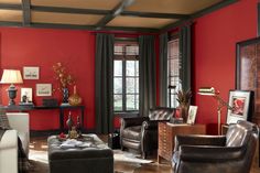 a living room with red walls and leather furniture