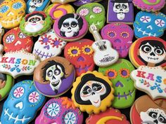 colorful sugar cookies decorated to look like skeletons and skulls with faces painted on them, all in different colors